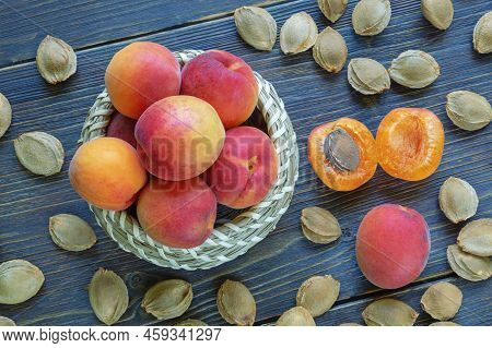 Ripe Apricots And Apricot Stones On Dark Rustic Table. Flat Lay