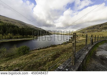 Beautiful Welsh Lake, Uk, With Old Fence In Foreground.