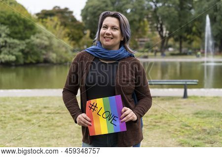 Love. Cheerful Queer Woman Holding A Message Supporting The Lgbt Community