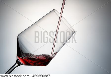 Close-up Of Filling A Crystal Glass With Red Wine. Pouring Red Wine Into A Crystal Glass Isolated On