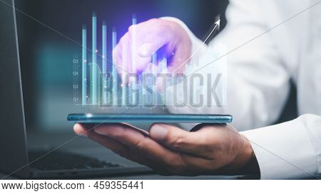Young Businessman Using The Phone To Analyze Stock Market Growth Charts, Trading And Business Invest