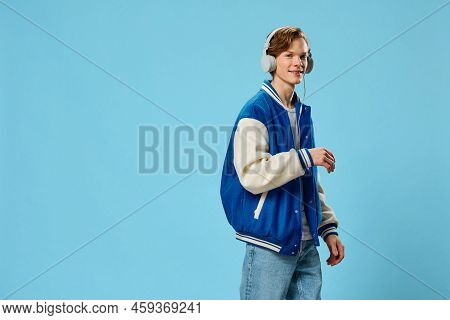A Handsome, Stylish Young Man In A Fashionable Jacket And With Large White Headphones On His Head St