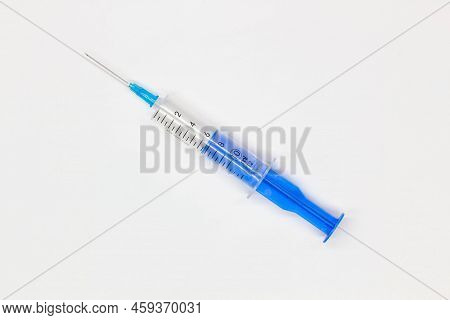 Blue Medical Disposable Syringe For Injection On A White Background. Medical Instrument For Vaccinat