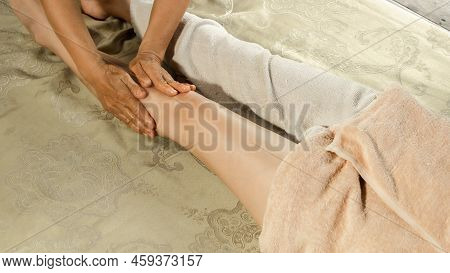 Asian Woman Enjoying A Salt Scrub Massage At Spa. Healthcare Spa And Massage Thai Concept  Girl Rece