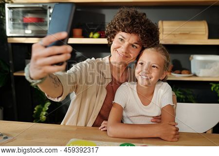 Happy Young Family Of Mother And Daughter With Smartphone Making Selfie
