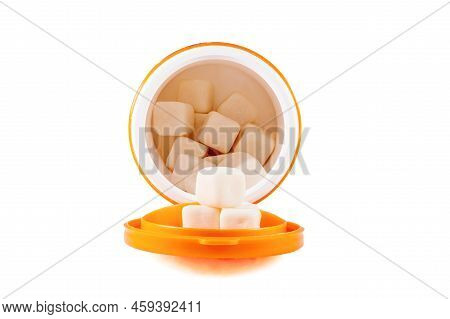 Gum In A Bottle On A White Background. Chewing Gum In The Form Of Cubes In An Open Jar. Close Up
