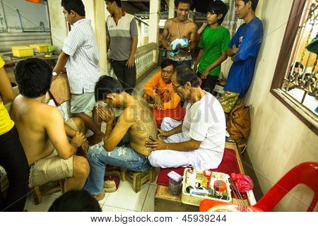 NAKHON CHAI, Tajlandia - MAR 23: Niezidentyfikowane mnich sprawia, że tradycyjne Yantra tatuażu w Wai pełna
