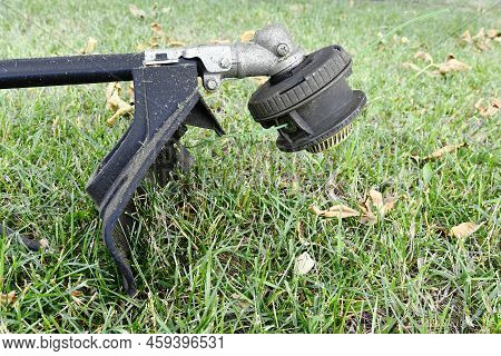 A Side View Image Of An Electric Weed Whacker Used For Lawn Edging And Maintenance.