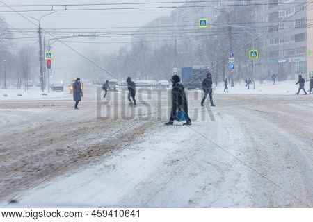 People In Winter Garment Crossing Winter Street During Heavy Snowfall In Daylight - December 25, 202