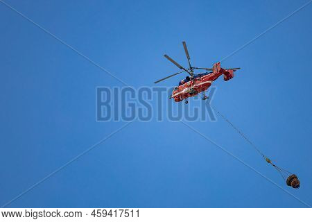 Moscow, Russia - July 21, 2022: Helicopter Carries Cargo In A Hanging Basket. High Quality Photo