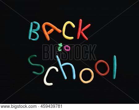 Handmade Words Of Multi-colored Plasticine Back To School In Wry Funny Style On Black Background