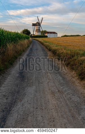 Early In The Morning There Is A Beautiful Windmill Whit The Sun Rising In The Sky