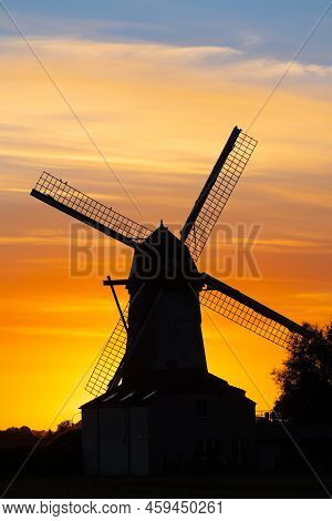 Early In The Morning There Is A Beautiful Windmill Whit The Sun Rising In The Sky