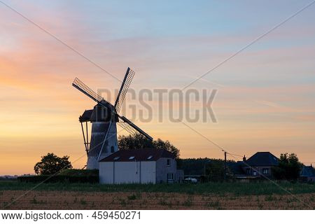 Early In The Morning There Is A Beautiful Windmill Whit The Sun Rising In The Sky