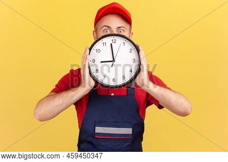 Unknown Worker Man Covering Half Of Face Behind Big Wall Clock, The Work Will Be Done On Time, Servi