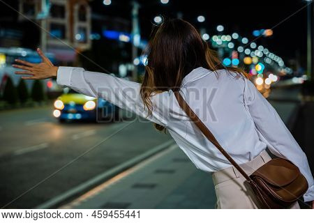 Back View, Beautiful Woman Smiling Using Smartphone Application Hailing With Hand Up Calling Cab Out