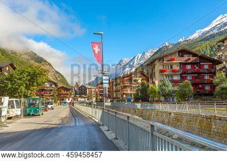 Zermatt, Switzerland - October 7, 2019: Town Street View In Famous Swiss Alps Ski Resort, River, Sno