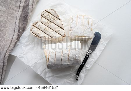 French Cheeses Heartshaped, Squared And Cylindrical Neufchatel Cow Cheese With Mold On White Paper,