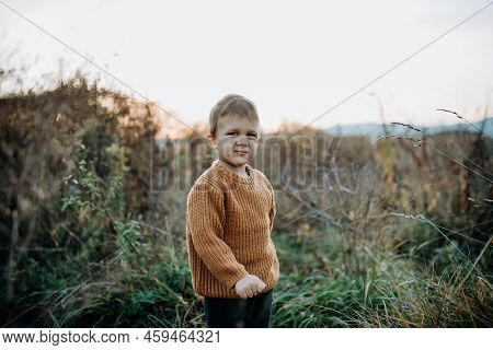 Portrait Of Cute Little Boy Wearing Knitted Sweater In Nautre, Autumn Concept.