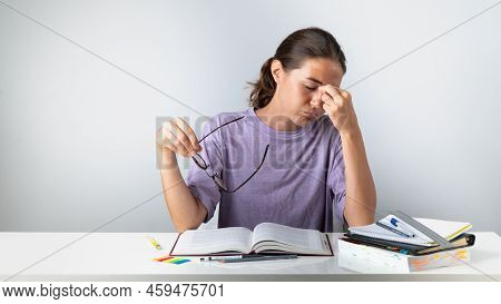 A Tired Student Takes Off His Glasses And Rubs His Eyes. High Quality Photo