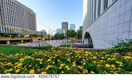 Madrid, Spain - July 30, 2022: Gardens With Flowers Among The Modern Glass And Steel Buildings In Th
