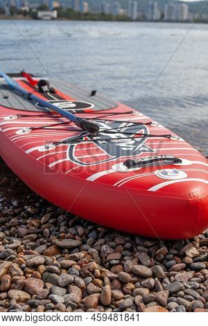 12.07.2022 Krasnoyarsk, Russia. Red Sup Board On The River Bank. Paddle Board On The Lake Shore. Sup