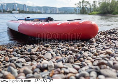 12.07.2022 Krasnoyarsk, Russia. Red Sup Board On The River Bank. Paddle Board On The Lake Shore. Sup