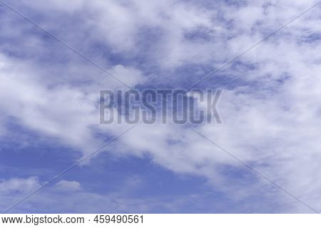 Blue Sky Background With White Fluffy Cumulus Clouds. Panorama Of White Fluffy Clouds In The Blue Sk
