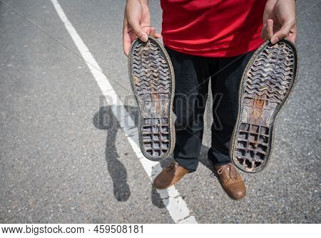 Cropped Shot Of Someone Holding A Pairs Of Rubber Outsole From Broken Shoes. Close-up Of Broken Leat