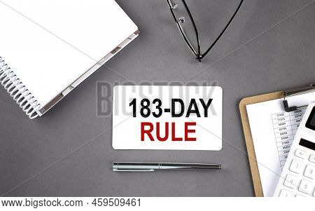 183-day Rule Text Written On Card With Notebook And Clipboard, Grey Background