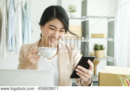 Happy Young Asian Female Freelan Sit In Online Clothing Store.