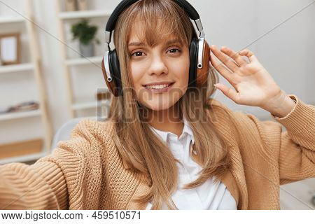 Cheerful Young Blonde Student Lady Freelancer In Warm Sweater In Headphones Listen Fav Songs Sitting