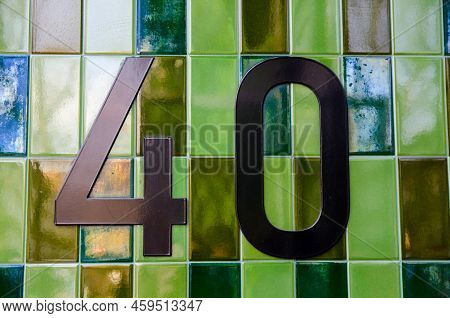 The Figure 40 Outside An Office Block In Central London.  Bronze Numbers Placed On Green Ceramic Til