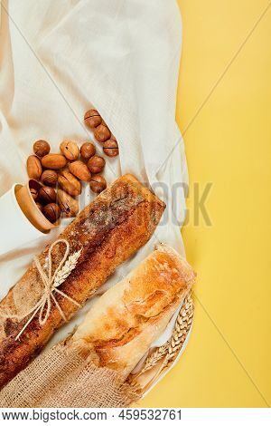 Top View Of Two Baguettebread And Nuts On A Textile Surface.