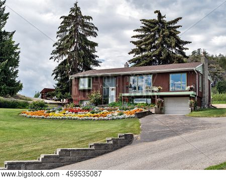 Old Residential House In Canada With Big Flower Bed On The Front Yard
