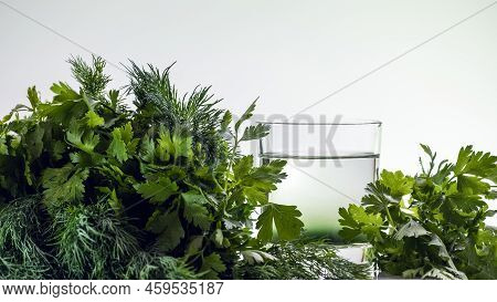 Chlorophyll Extract Is Poured In Pure Water In Glass Against A White Background And Green Organic Di