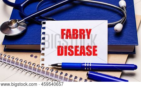 On The Table Are Notepads, A Stethoscope, A Pen And A Sheet Of Paper With The Text Fabry Disease. Me