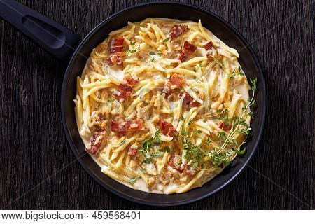 Capunti Pasta In Cream Pecorino Cheese And Pancetta Sauce On Pan On Dark Wooden Table, Flat Lay, Clo