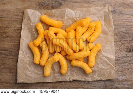 Many Tasty Cheesy Corn Puffs On Wooden Table, Top View