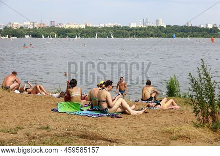Moscow, Russia - August 2022: People Sunbathing On A Beach On Background Of Moscow River In Strogino