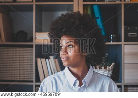 Attractive Dark Skinned Young Woman With Curly Afro Hairstyle Looking Out Through Window. Thoughtful