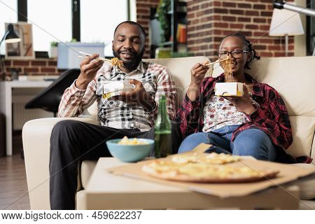 Man And Woman Eating Noodles From Takeout Delivery Box, Having Fun With Fast Food Takeaway Meal On C