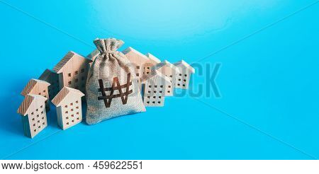 South Korean Won Money Bag Surrounded By Houses. Buying Apartments. Real Estate Investment. Budget A