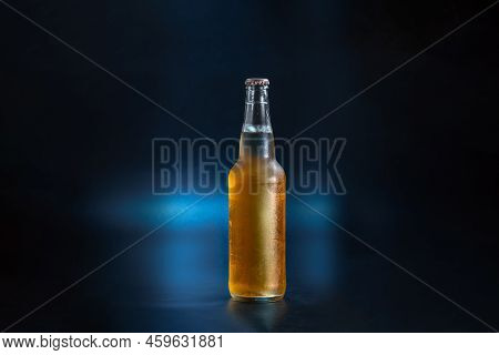 Unlabeled Bottle Of Lemonade On A Dark Blue Background. The Bottle Of Kambucha Is Fogged Up. Cold Bo