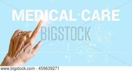Hand Of Elderly Woman Points To Inscription Medical Care On A Light Blue Background With Medical Ico