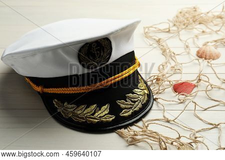 Peaked Cap, Net And Shells On White Wooden Background, Space For Text