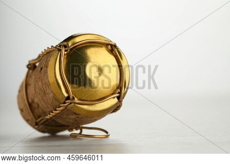 Cork Of Sparkling Wine And Muselet Cap On White Wooden Table, Closeup. Space For Text