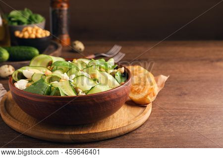 Delicious Cucumber Salad And Rosted Bread Served On Wooden Table. Space For Text