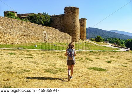 Woman Strolling Through The Countryside In Summer With A Medieval Castle In The Background On The Hi