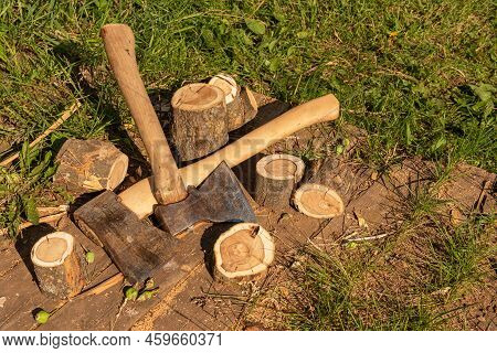 The Axes Are Lying Next To The Wooden Chocks. Preparation Of Firewood For Kindling. Stumps With Axes